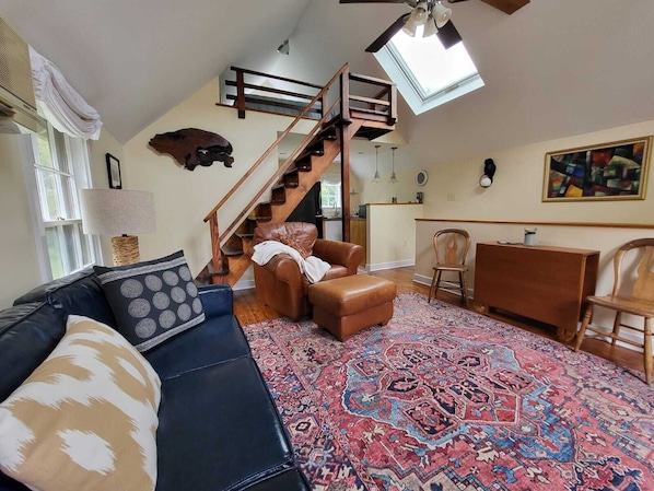 Vaulted ceiling great room with staircase to upper loft bedroom with queen bed.