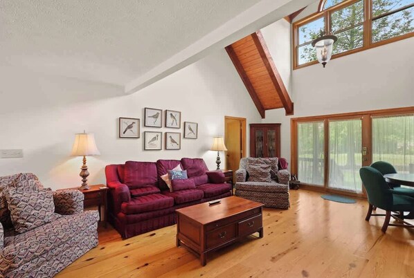 Unwind in the first-floor living room surrounded by the beauty of nature. Large windows frame picturesque views, creating a serene and inviting space.