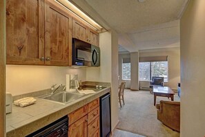 The efficiency kitchen includes a dishwasher, mini fridge, sink, stovetop and microwave.