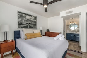 Primary Bedroom featuring a Queen bed with bedroom furnishings, access to the back private patio, and an ensuite primary bathroom.