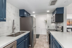 Fully equipped kitchen with stainless-steel appliances and stocked with all culinary essentials.