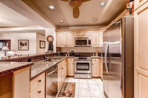 Prepare your meals in the fully-equipped kitchen featuring modern stainless steel appliances and granite countertops