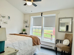 Comfy queen bed with black out shades and view of the fields and barn next door.