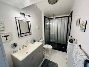 Bathroom is stocked & has a rainfall shower head with galvanized roofing walls