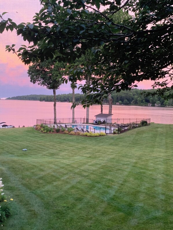 Pink sunset view from the condo balcony with community swimming pool in sight
