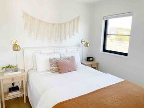 Bedroom #2 with a soft linen duvet,  and a bedside table with an alarm clock and USB port. Beautiful hillside views greet you in the morning! 