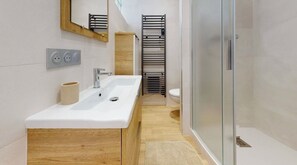 Large shower, basin with plenty of storage, suspended toilet & towel heater. 