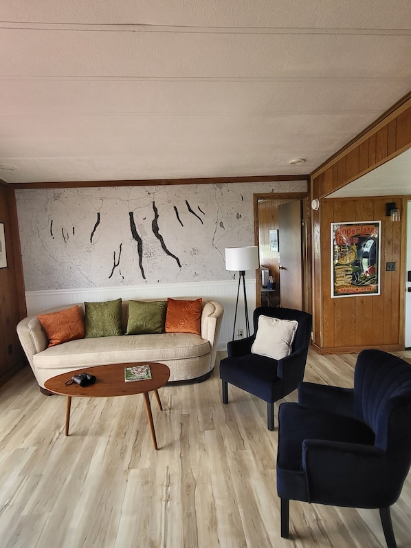 Living room area featuring Finger Lakes mural, comfy sofa and chairs