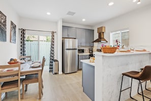 Awaken your inner foodie in our well-appointed kitchen, equipped with high-end appliances, a four-person dining table, and inviting counter-height stools