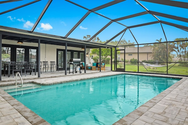 A beautiful pool is nestled within a screened-in patio, offering a serene oasis shielded from insects and the elements. This enchanting setup allows residents and guests to enjoy a refreshing swim or simply lounge by the poolside, surrounded by the beauty of the outdoors without any disturbances. It provides a tranquil and private space to unwind, soak up the sun, and relish mo...