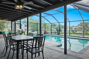 An outdoor table positioned by the pool provides a charming spot for al fresco dining and relaxation. Surrounded by the serene ambiance of the poolside, it offers a perfect setting for enjoying meals, snacks, or refreshing beverages outdoors. This outdoor dining area creates a picturesque atmosphere for leisurely moments, making it an inviting space to gather, dine, and unwind...