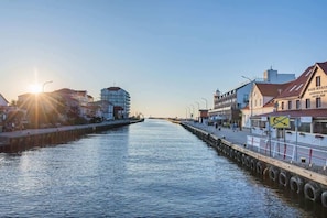 A peaceful canal view during sunset, showcasing charming waterfront architecture and reflections on the water.

