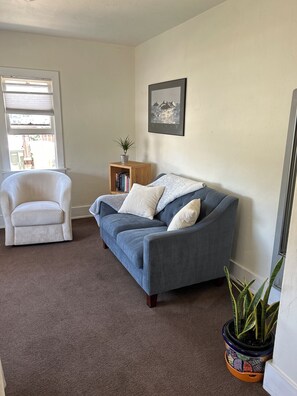 Living room with love seat and two swivel chairs. 