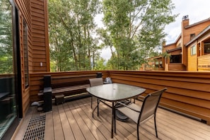 The spacious private balcony offers a table and chairs, additional bench, and a private grill.