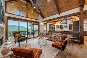 Panoramic mountain views sweep across glass windows and doors from living room to kitchen in this open floor plan meant for entertaining and relaxation.