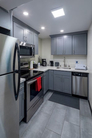 Kitchen with full-size fridge, electric oven and bar dishwasher