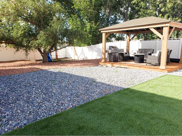 Massive yard with gazebo, fire pit, play set, grass turf area, BBQ and views!