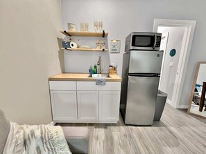 Kitchenette, complete with cookware, a two burner stovetop, fridge, freezer, and microwave!