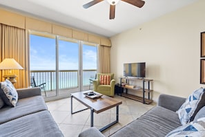 Living Room - Unwind in comfort in this open beachfront living area with a large flat-screen TV and floor-to-ceiling windows framing stunning sea views.