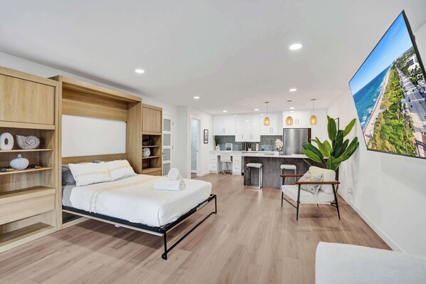 Studio includes murphy bed with a queen mattress, sofa bed that pulls out a full-size bed for two individuals, and large 75" smart TV.