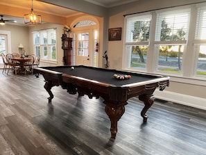 The vintage “over-sized 8” foot pool table offers sunset views between shots. 