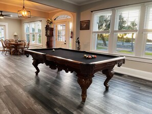 The vintage “over-sized 8” foot pool table offers sunset views between shots. 