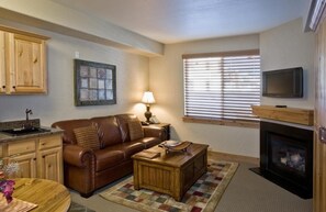 Relax in the cozy living area, complete with fireplace and TV