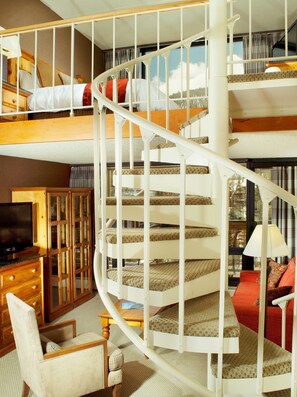 The spiral staircase leads to the loft bedroom with luxe King bed.