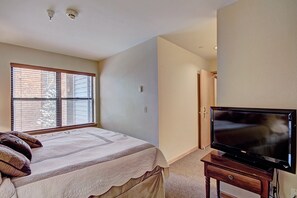 The hotel room includes a flat screen TV, bed and coffee maker