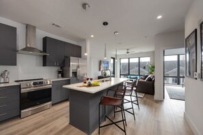 Fully equipped kitchen stocked with your basic cooking essentials. Includes stainless steel appliances, small kitchen island, coffee machine, and toaster.