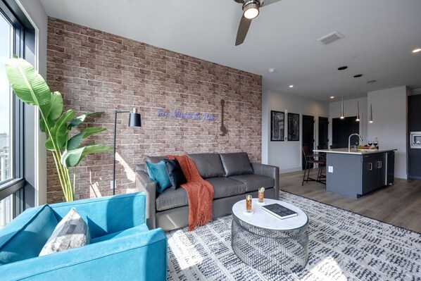 Bright open concept living area with floor to ceiling windows providing panoramic views of Midtown! Features designer furniture and smart TV!