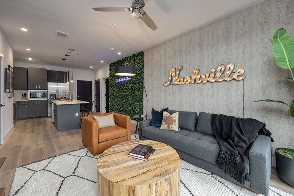 Warm and inviting living room featuring cozy designer furnishings, a Smart TV for entertainment, and a private balcony.
