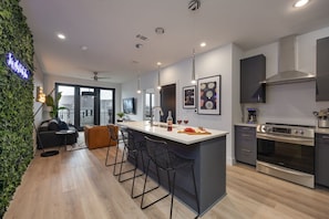 Fully equipped kitchen featuring stainless-steel appliances and stocked with culinary essentials for ease and convenience during your stay.