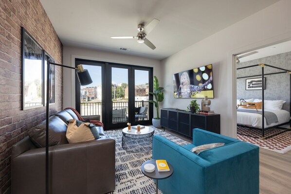 Welcome to a bright and open concept living room that exudes modern elegance. Designer furnishings enhance the sophistication of the space, while a smart TV provides entertainment options and a pull-out couch.