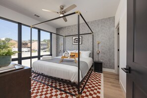The primary bedroom is a lavish sanctuary featuring a spacious King bed and floor-to-ceiling windows. It's equipped with a Smart TV for entertainment, a luxurious en-suite bathroom for convenience, and a walk-in closet to accommodate all your belongings.