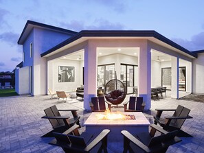 California style doors to large private patio. Patio features outdoor dining table for 8, lounge area, and fire pit.