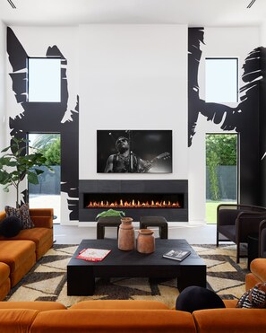 Professionally and intricately designed modern styled living area with large hand-painted mural, 20 ft vaulted ceilings, large electric fireplace, large smart TV, and complete with designer furnishings.
