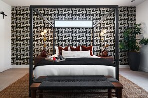 Primary suite with large king bed, lounge area, access to backyard, smart TV, designer furnishings, large walk-in closet, and en-suite bathroom