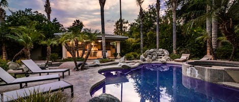 Private Resort-like backyard featuring a sparkling blue pool, covered patio with outdoor lounging and dining, sun lounger for basking, and a BBQ grill.