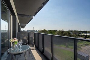 A spacious balcony with a small table, two chairs, and a scenic view, offering a perfect spot to relax.
