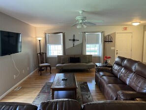 The Federal House Apartment 2 living room with futon for extra sleeping and a large smart TV.