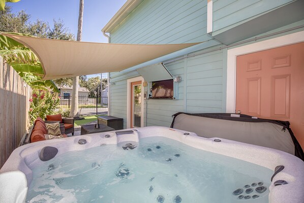 Spacious and relaxing patio with hot tub, fire table, and smart TV.