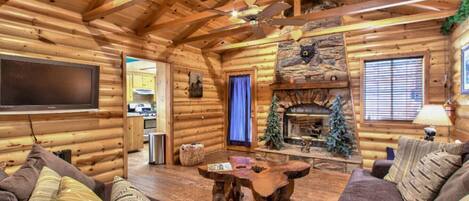 The log cabin living room has an L-shaped couch and a gas fireplace.