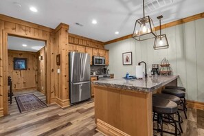 The well-equipped kitchen has stainless steel appliances, a kitchen bar with 4 bar stools, and all the basic appliances and cookware to prepare a delicious meal.