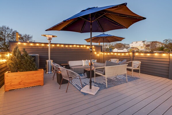 Elevate your Downtown Nashville getaway at this stunning rooftop oasis, ideal for skyline views! Perfect for bachelorette parties or corporate retreats, this chic space offers cozy seating and twinkling lights for unforgettable moments.
