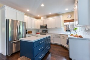 With a full fridge/freezer, kitchen island and plenty of counter space, preparing a meal  here is easily accessible.