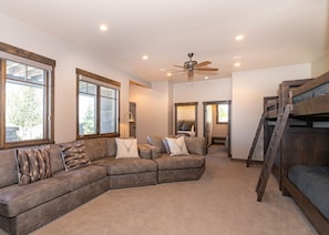 Lower level great room with TV, seating, twin bunks, and queen size Murphy bed