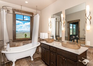 Master suite bathroom featuring a double vanity and clawfoot soaking tub