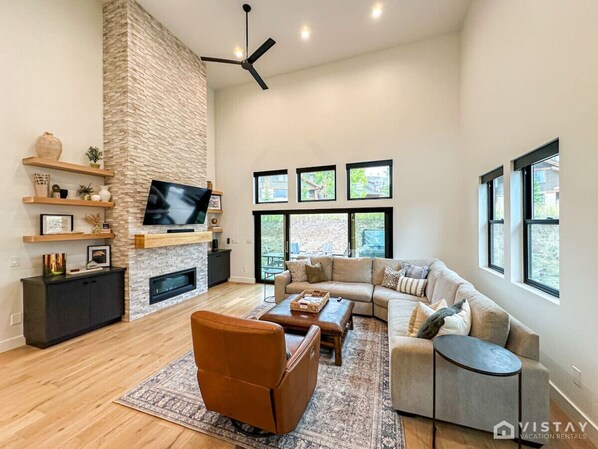 The spacious open-concept living area features beautiful hardwood floors, modern fixtures, and high-end furniture, creating an atmosphere of pure luxury and comfort.
