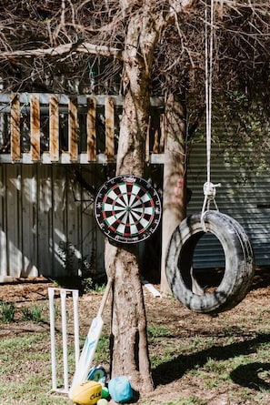 This home is made for families with outdoor play equipment including a tyre swing, darts, and backyard cricket.
